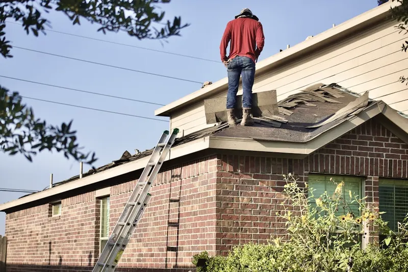 Professional roofer working on a residential roof in Cain Manor